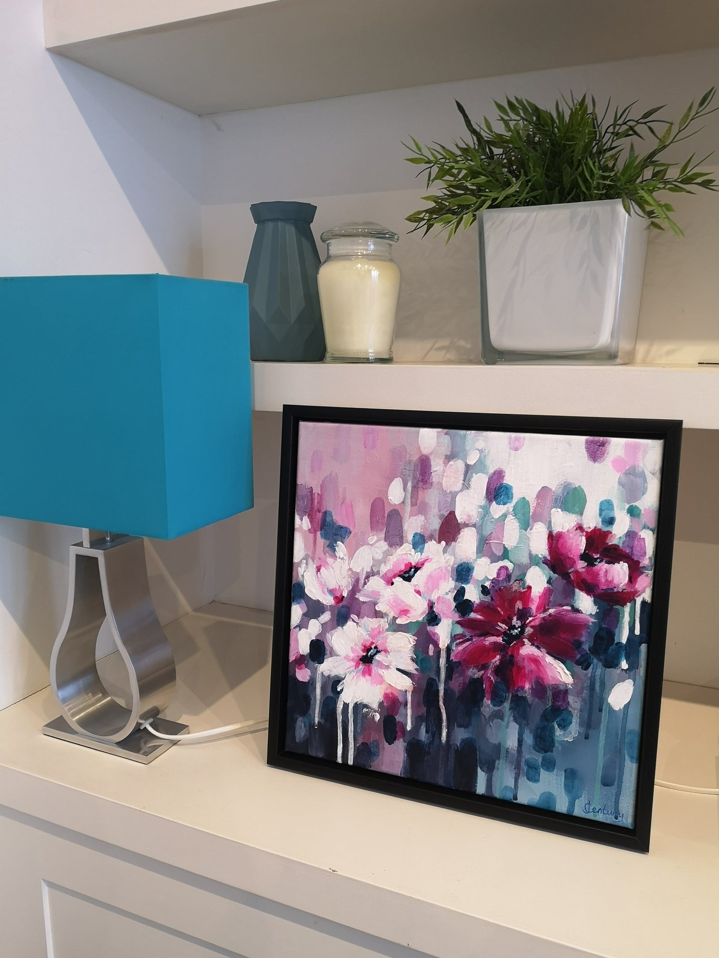 Abstract floral painting in interior setting with blue lamp, plants and vase and candles ornaments