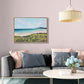 Living room with a gray sofa, coffee table, and wall art of a beach scene.