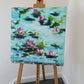 Abstract lily pad pond acrylic painting displayed on wooden artist easel in studio