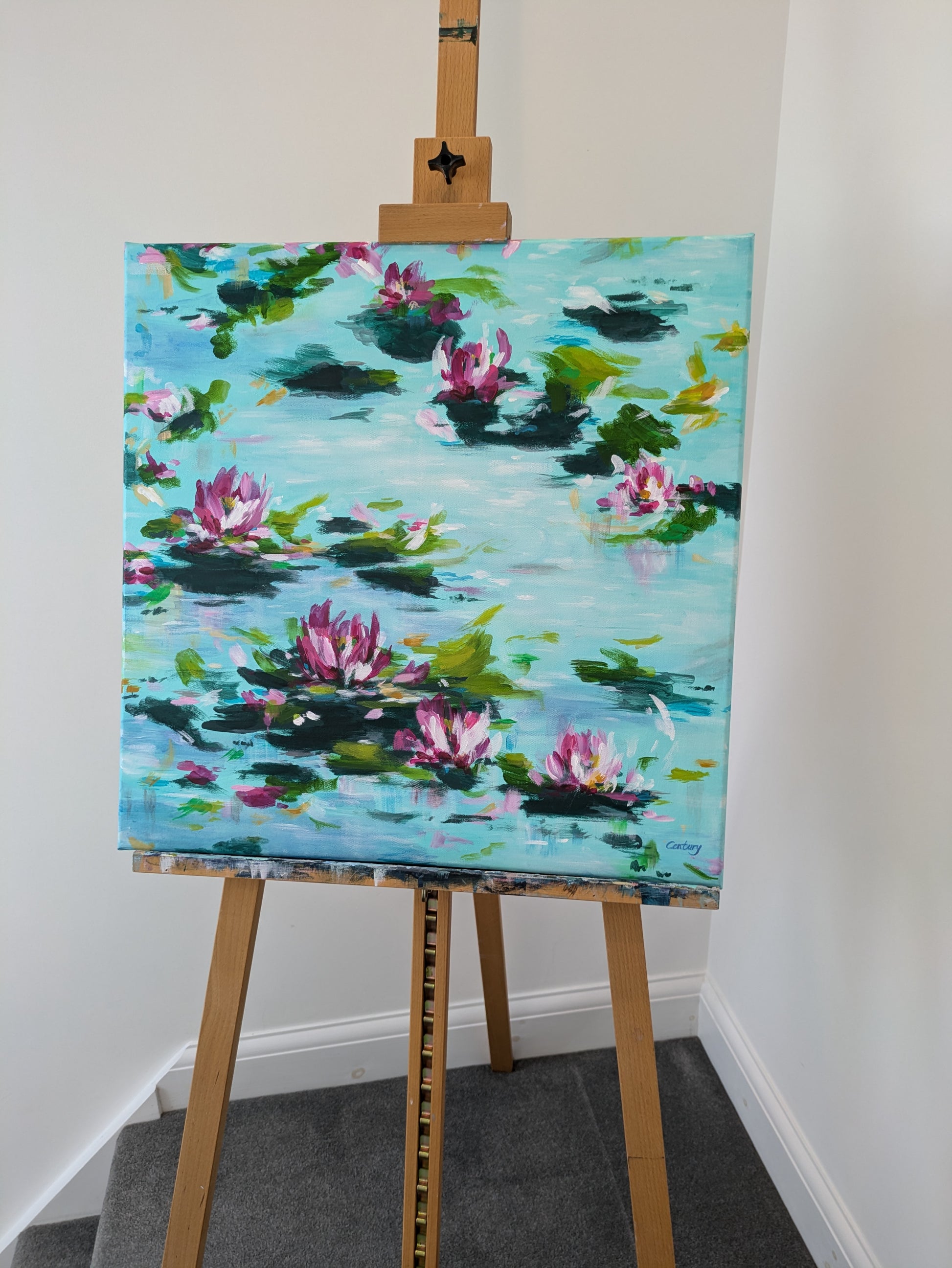 Abstract lily pad pond acrylic painting displayed on wooden artist easel in studio