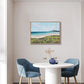 Dining room with a round table and two blue chairs, featuring a framed landscape painting on the wall.