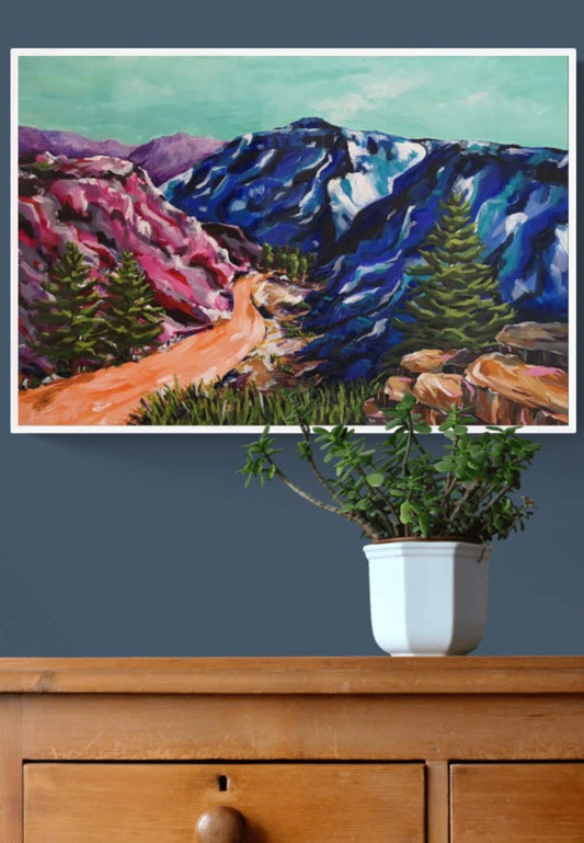 Home Decor styling of Vibrant, colourful Abstract Landscape painting by Judy Century. Mountain adventure acrylic canvas wall art hanging on navy wall above wooden chest of drawers.