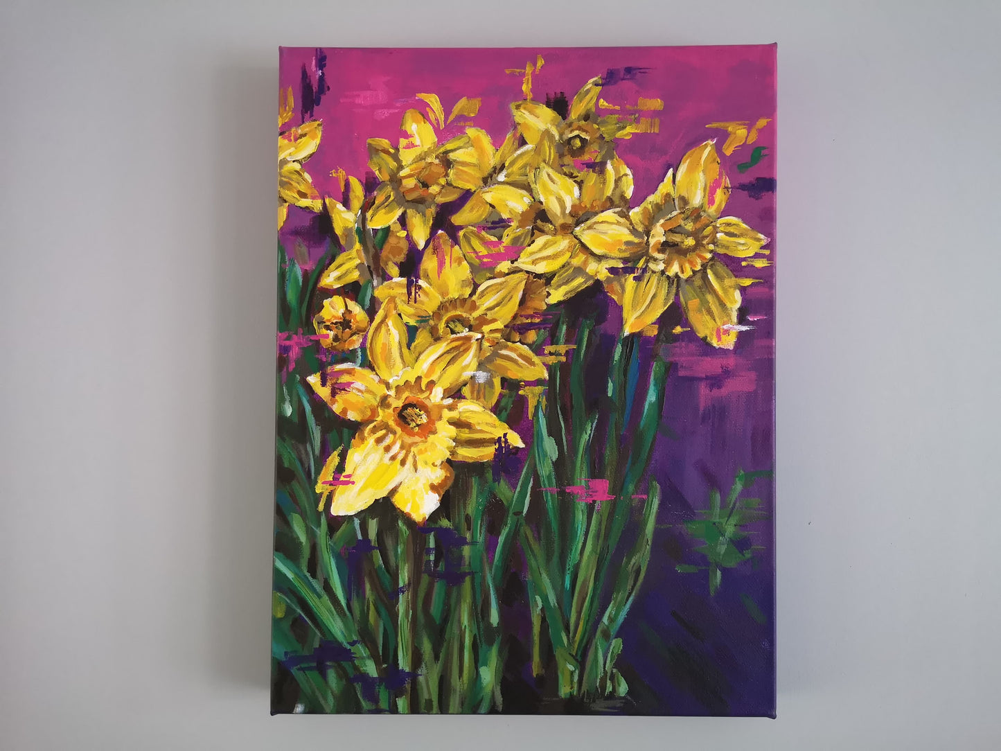 Contemporary vibrant daffodil painting by Judy Century Art. Semi Abstract painting featuring colourful yellow, purples and pinks. Canvas painting hanging on grey wall