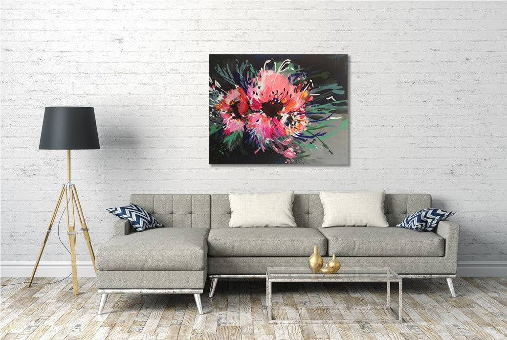 Large Abstract Expressive Floral Canvas painting by Judy Century Art. Flower Power Acyrlic artwork with large pink blooms hanging on white brick wall above grey couch with wooden floor and charcoal lamp