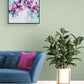 Contemporary original abstract floral painting by Judy Century 'Fancy Free' 61x61cm in stylish living room with blue sofa, large plants, green walls