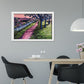 Colourful abstract landscape of an enchanting woodland scene with a shady path, trees, a river and colourful abstract bushes. Acrylic painting by Judy Century Art framed in white hanging above a dining table with black chairs