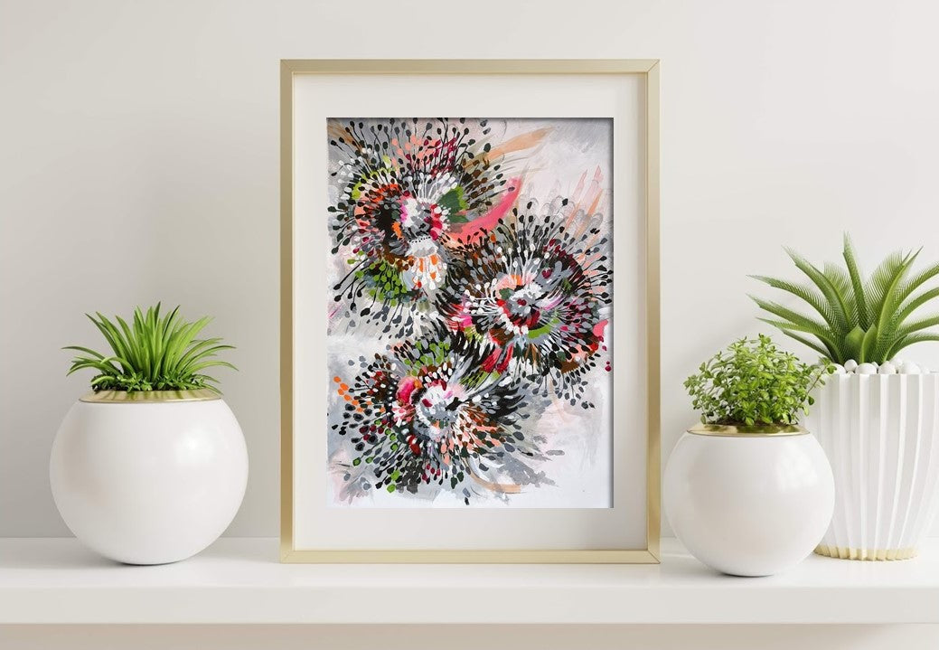Original Acrylic painting on paper by Judy Century Art. Inspired by flowers, this painting is full of movement and energy, called spokes and spikes. Featuring grey, green, pink, black, brown, peach and white. Gold frame sitting on white shelf with green plants.