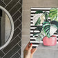 Plant painting, variegated Monstera cheese plant acrylic painting on A4 canvas with bold black and white striped pattern background. Shown in a grey and black bathroom for home decorating ideas