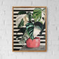 Plant painting, variegated Monstera cheese plant acrylic painting on A4 canvas with bold black and white striped pattern background. Painting hangs on white brick wall with an oak frame for wall art ideas