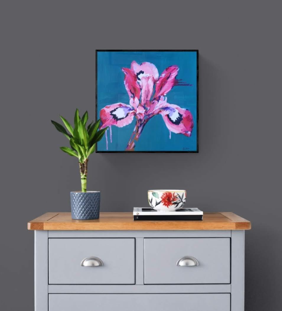 Original Abstract Iris Flower Painting hanging on a grey wall above chest of drawers. Colourful wall art by Judy Century