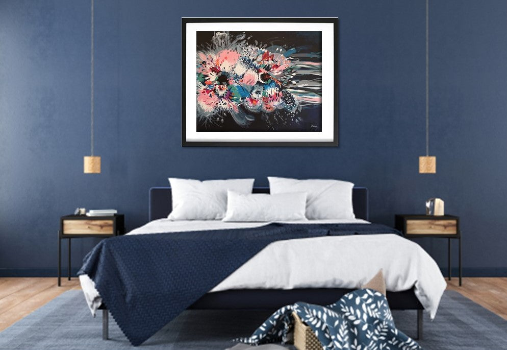 Art print of Large Abstract acrylic painting of Hibiscus flower by Judy Century Art. Pictured in a black frame hanging on a navy wall above a double bed with wooden accessories. Also with bold, bright colours, of blue, pink, green, white, green and navy with expressive lines flowing out.